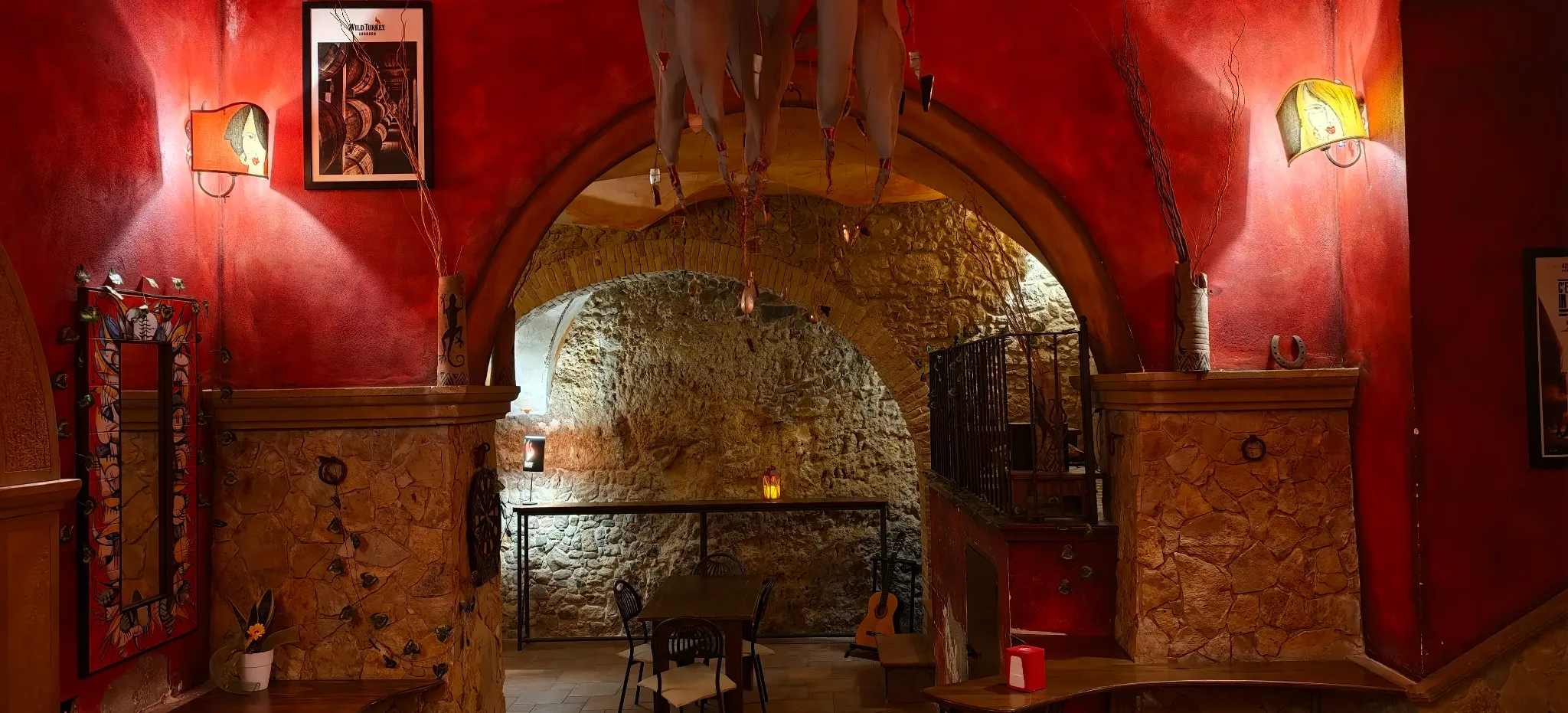 Arco rosso che conduce alla sala con pareti in pietra