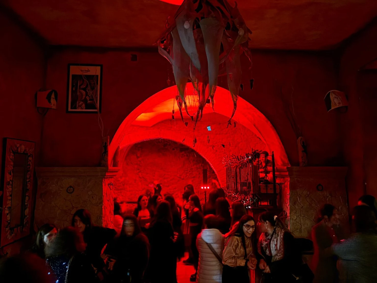 La sala del Nessun Dorma: archi di pietra, luci rosse e persone insieme