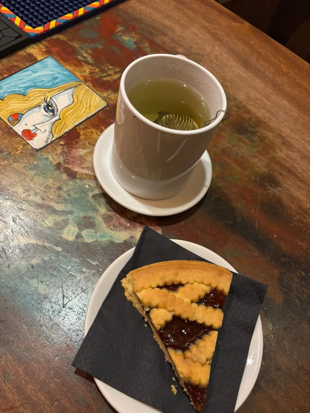 Una tisana e una fetta di crostata sul tavolo del locale